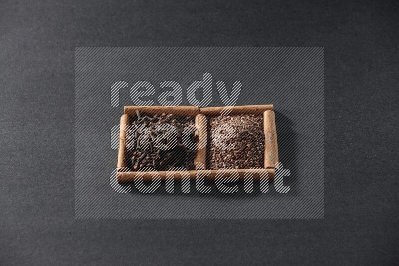 2 squares of cinnamon sticks full of flaxseeds and cloves on black flooring