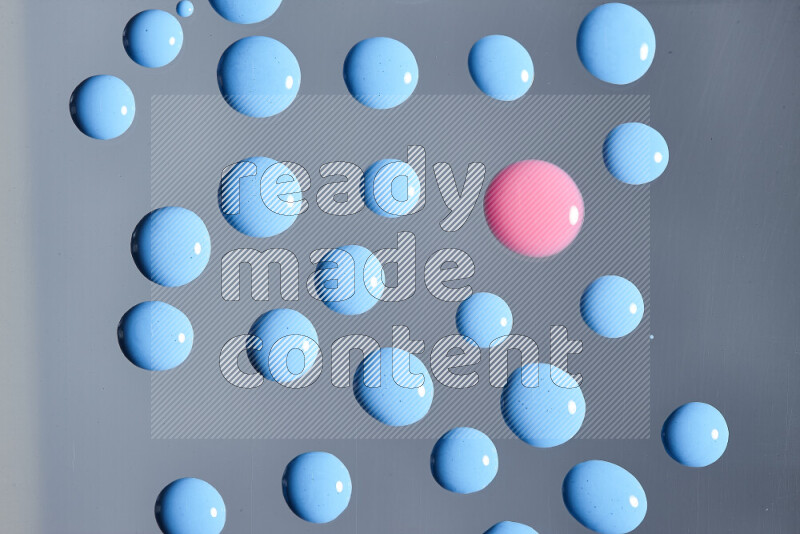 Close-ups of abstract pink and blue paint droplets on the surface
