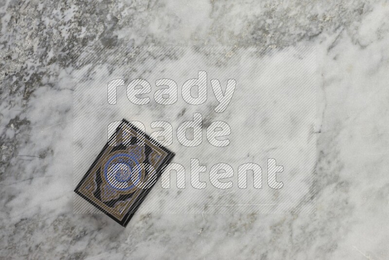 Quran with a prayer beads on grey marble background