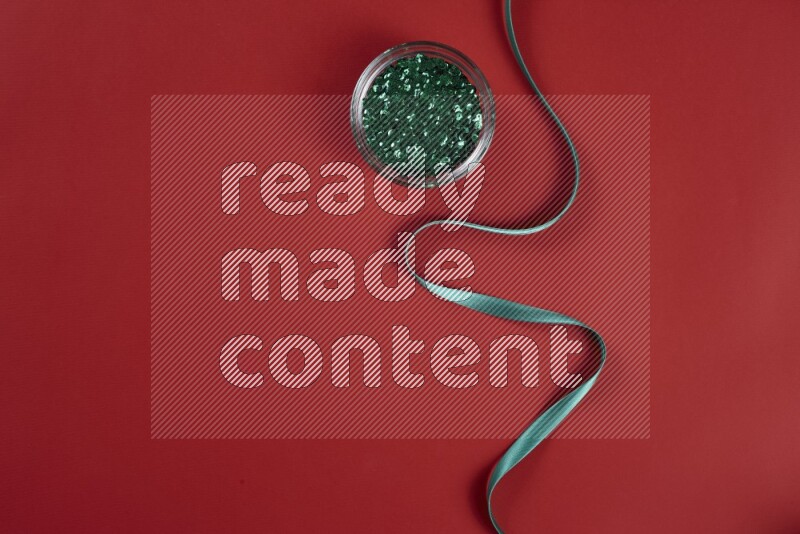 مجموعة من أدوات الخياطة والتفصيل خضراء وحمراء اللون على خلفية حمراء