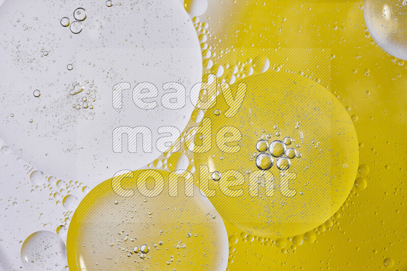 Close-ups of abstract oil bubbles on water surface in shades of white and yellow