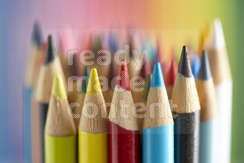 The image captures a close-up of sharpened colored pencils on multicolored background
