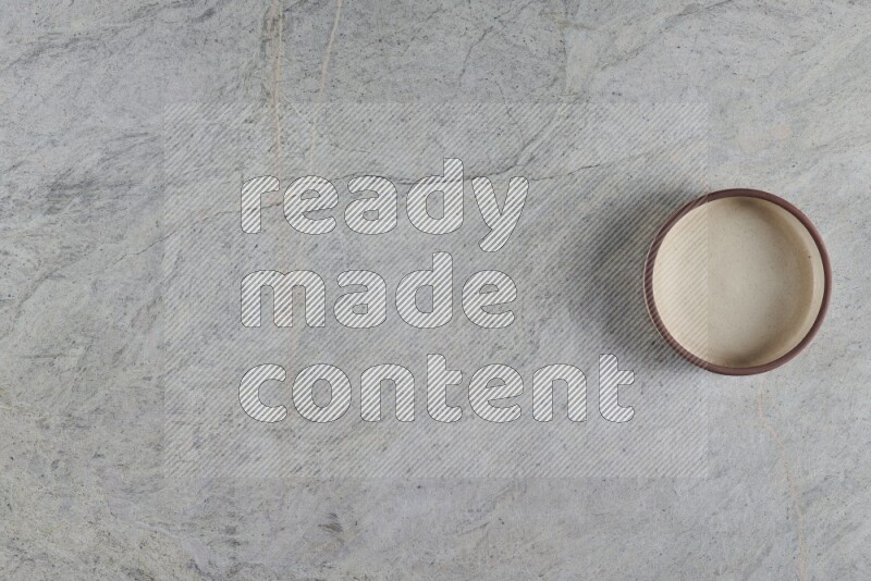 وعاء فرن فخاري متعدد الألوان على خلفية من الرخام الرمادي