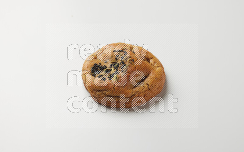 Hasawi cookie field with date and decorated by black seed and Anise grain on a white background