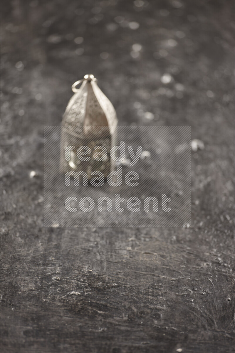 A lantern placed on a textured black background