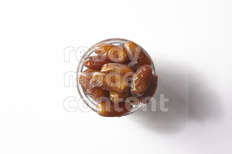 Dates in a glass bowl on white background
