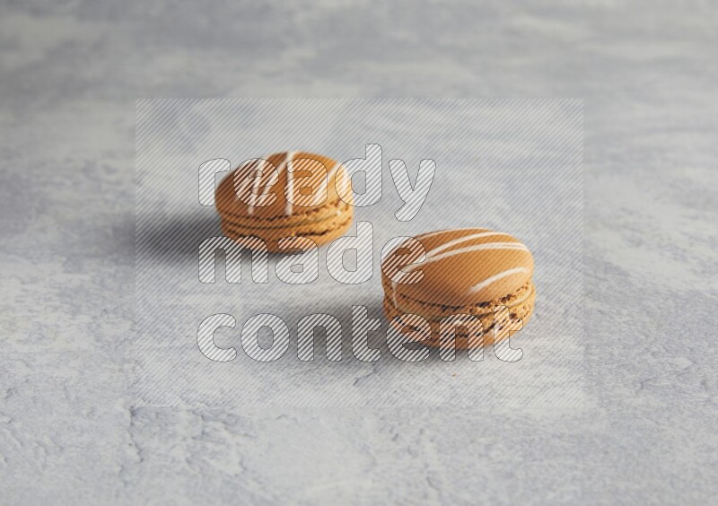 45º Shot of two Brown Irish Cream macarons  on white  marble background