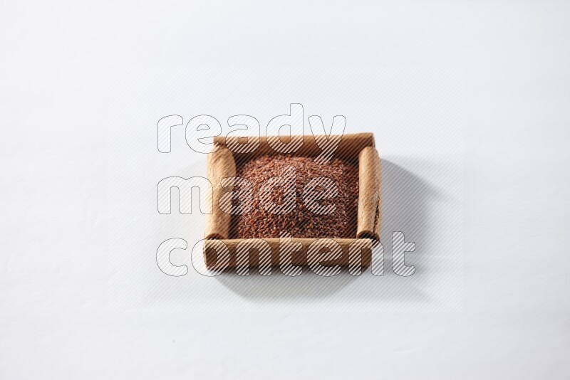 A single square of cinnamon sticks full of garden cress on white flooring