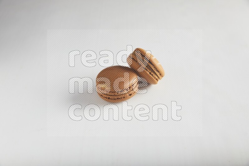 45º Shot of of two assorted Brown Irish Cream, and Brown Coffee macarons  on white background