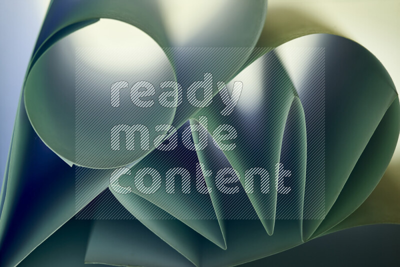An artistic display of paper folds creating a harmonious blend of geometric shapes, highlighted by soft lighting in green tones