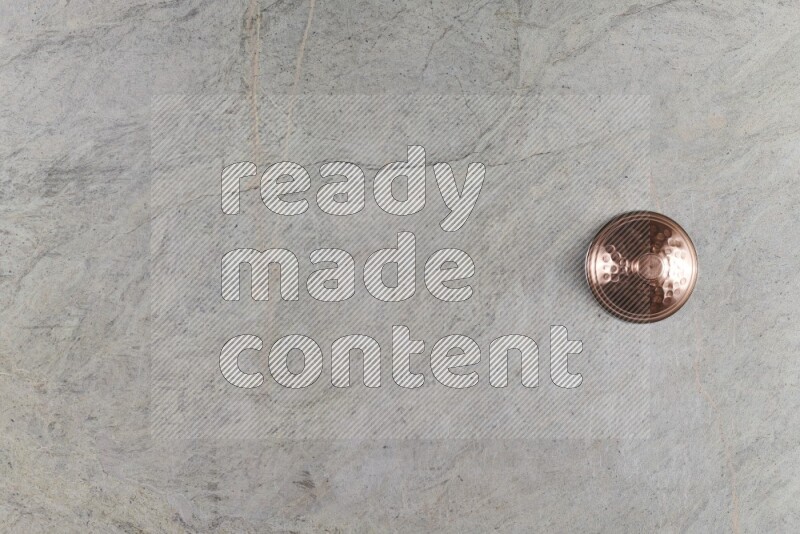 A small copper pot on grey marble background