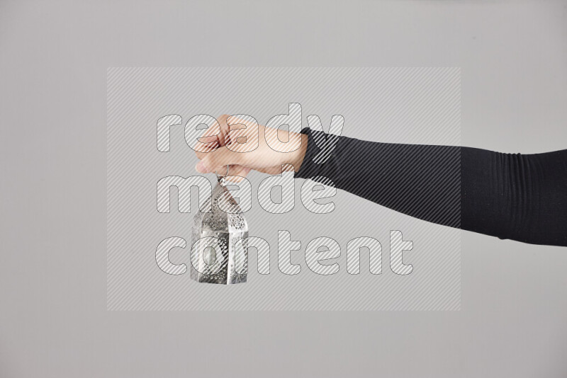 A woman in black abaya holding different ramadan lanterns in different positions