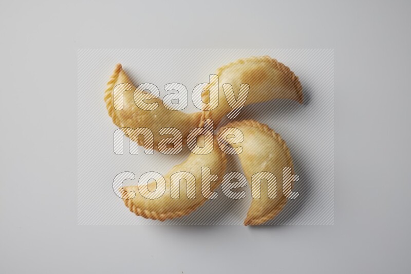 Four fried sambosa from a top angle on a white background