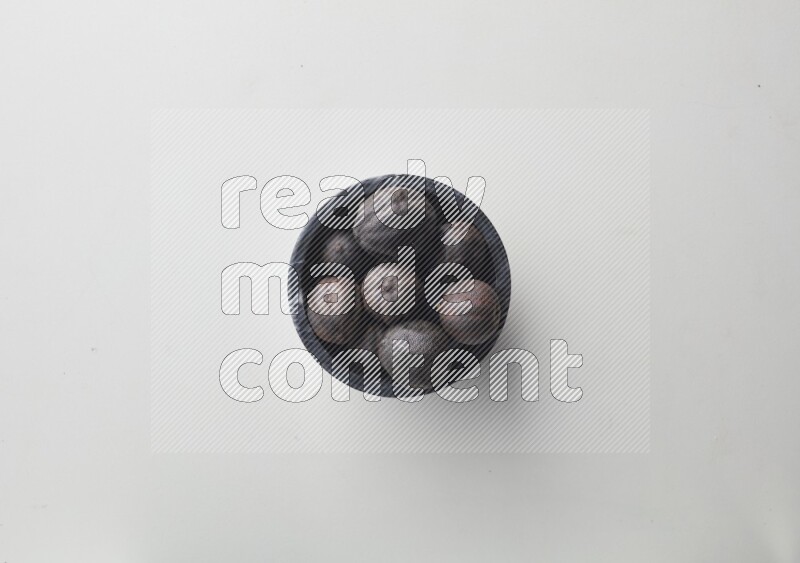 Top-view shot of dried lime (loomi) in a container on white background