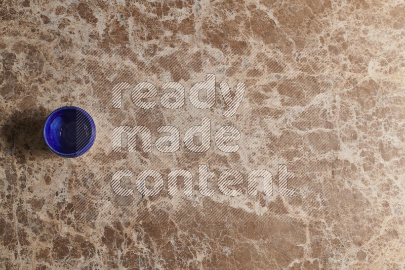 A pottery cup on beige marble background