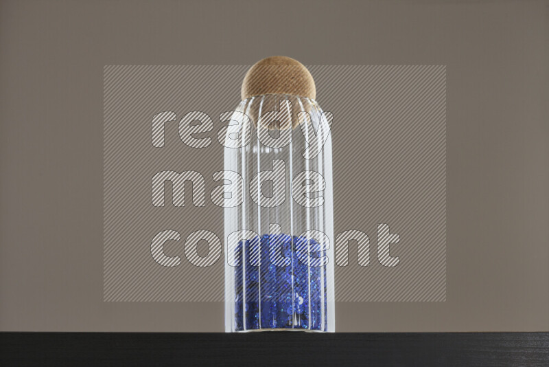 Sequins in a glass jar on black background