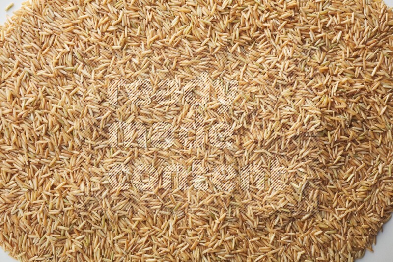 Top-view shot of long grain brown rice on white background