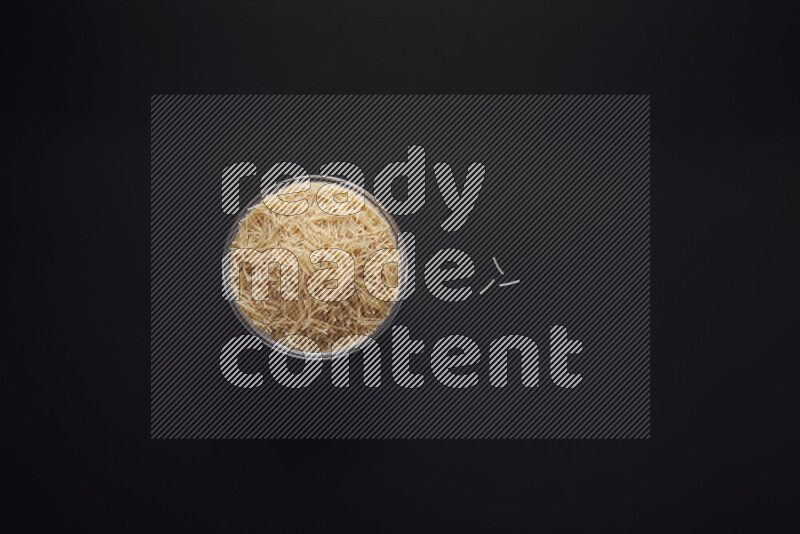 Vermicelli pasta in a glass bowl on black background