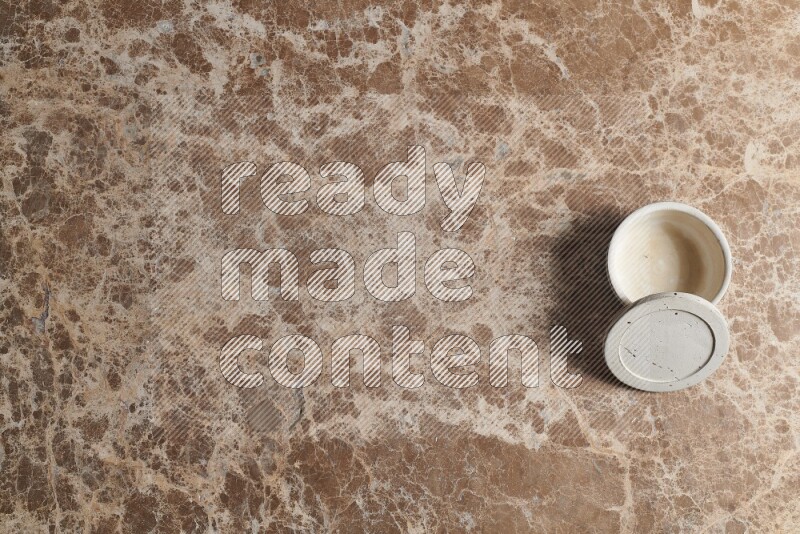 A pottery cup on beige marble background