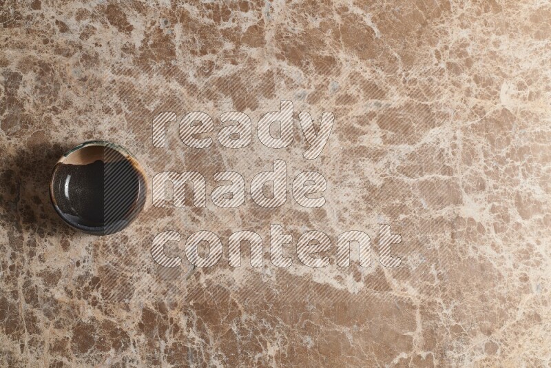 وعاء فخاري متعدد الألوان على خلفية من الرخام البيج