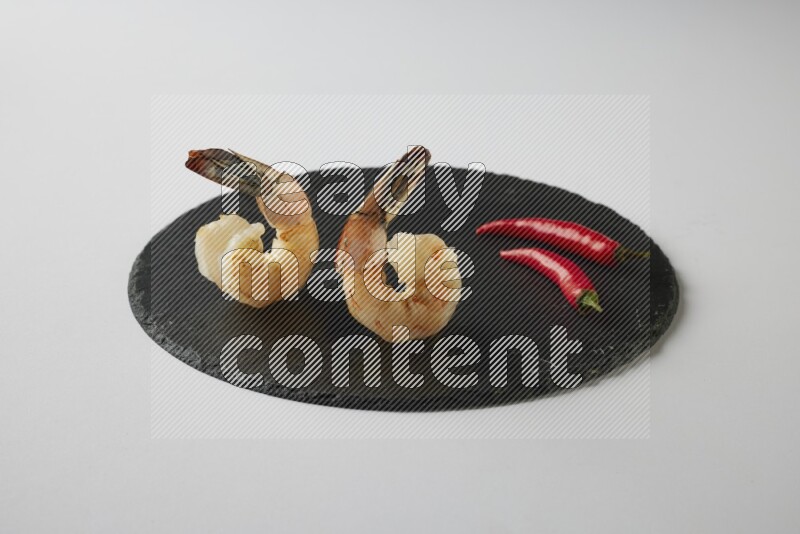 two grilled shrimp  on a black slate direct  on a white back ground