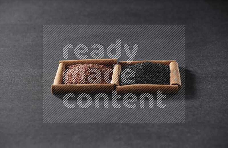 2 squares of cinnamon sticks full of garden cress and black seeds on black flooring