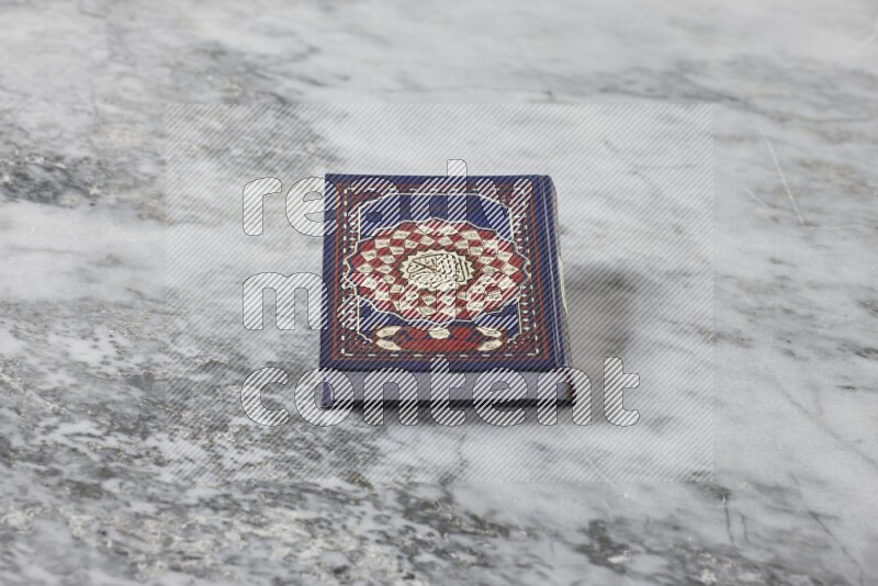Quran with a prayer beads on grey marble background