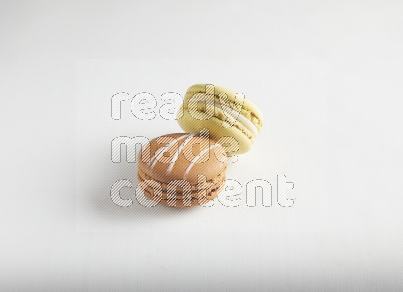 45º Shot of of two assorted Brown Irish Cream, and Yellow Lime macarons on white background