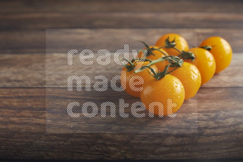 yellow cherry tomato vein on a textured wooden background 45 degree