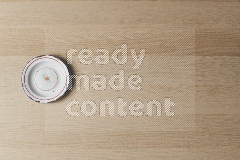 صحن معدني عتيق على خلفية خشبية فاتحة