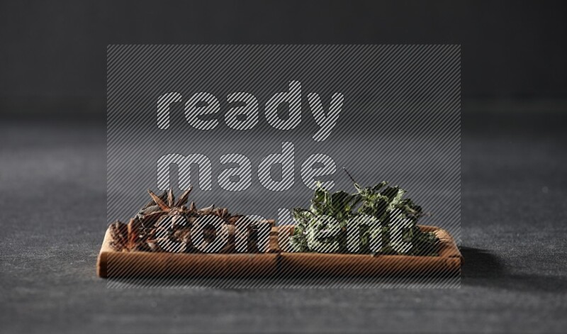 2 squares of cinnamon sticks full of star anise and dried mint leaves on black flooring