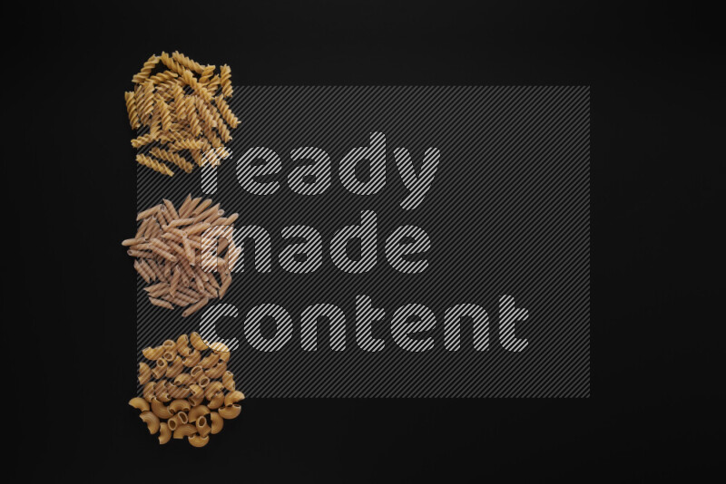 Different pasta types in 3 bunches on black background