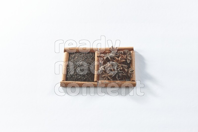 2 squares of cinnamon sticks full of black tea and star anise on white flooring