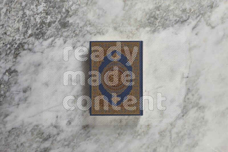 Quran with a prayer beads on grey marble background