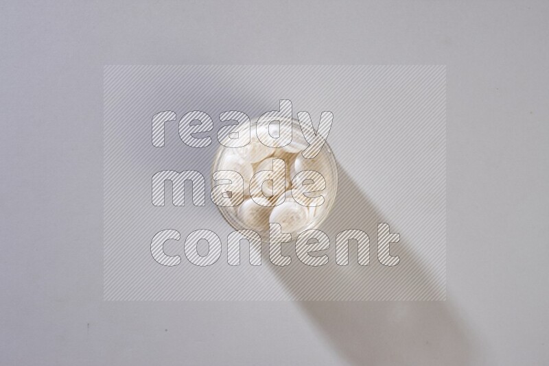 Colored buttons in a glass jar on grey background