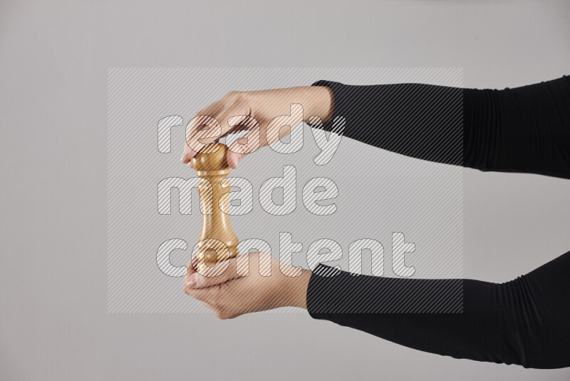 A woman in black abaya holding different wooden essentials in different positions