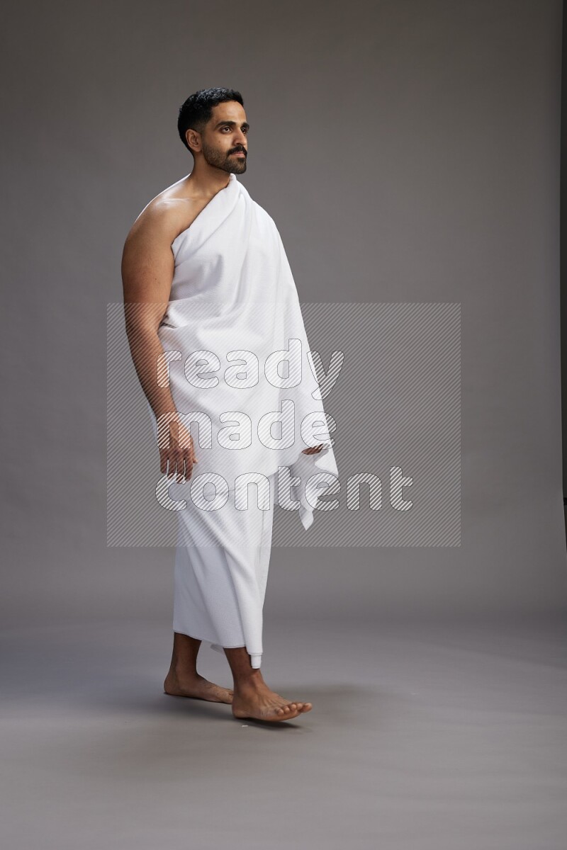 A man wearing Ehram Standing Interacting with the camera on gray background