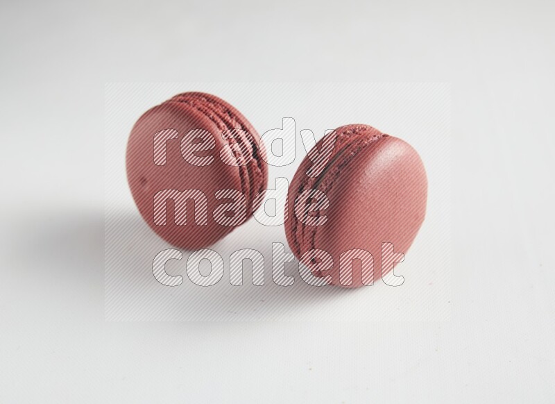 45º Shot of two Red Velvet macarons on white background