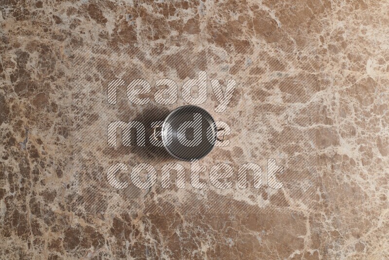 A small copper pot on beige marble background