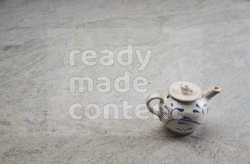 A pottery teapot on grey marble background