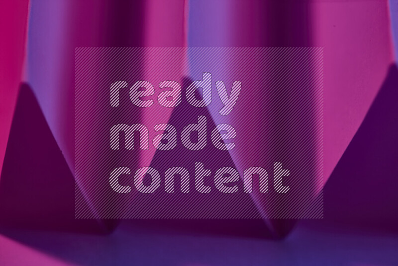 A close-up abstract image showing sharp geometric paper folds in purple gradients