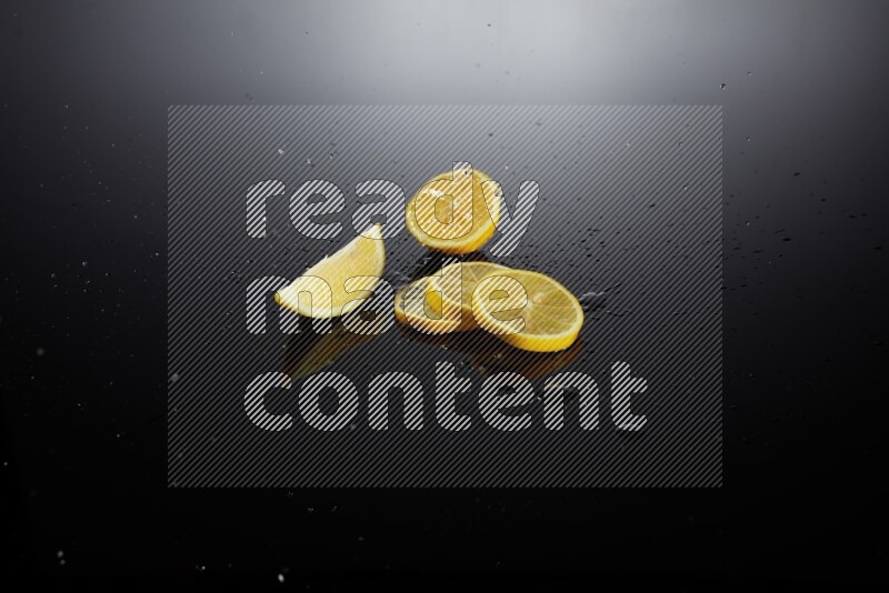 Lemon slices with water drops, and droplets on black background