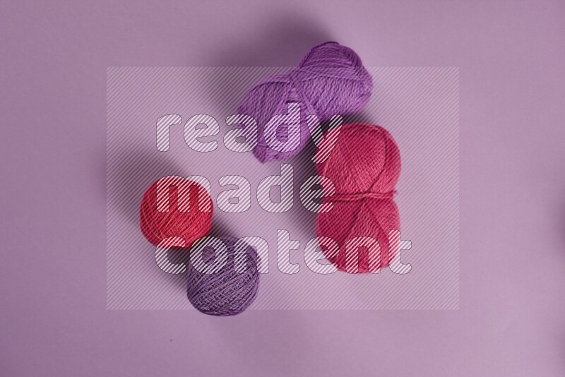 A pink and purple collection of sewing and tailoring tools arranged on a purple background