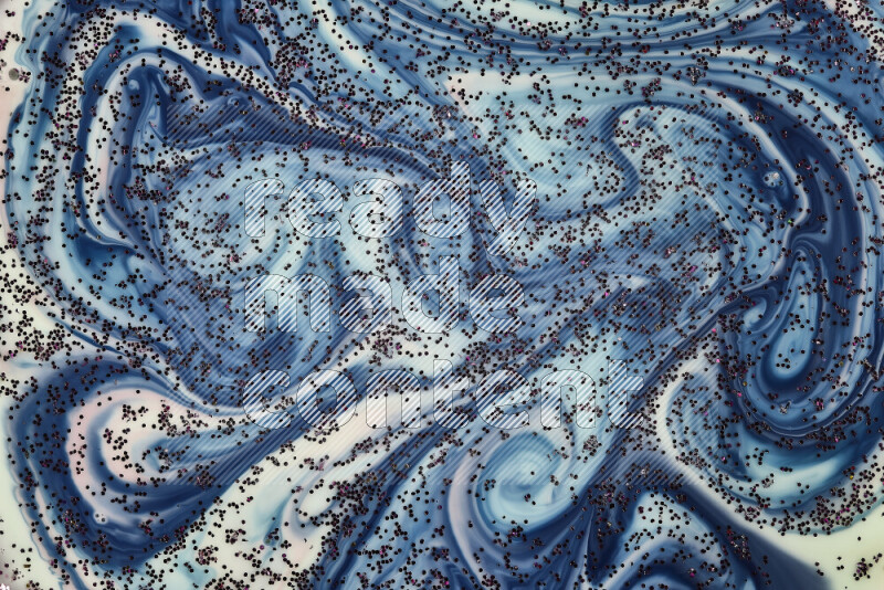 A close-up of sparkling purple glitter scattered on swirling green, red and blue background