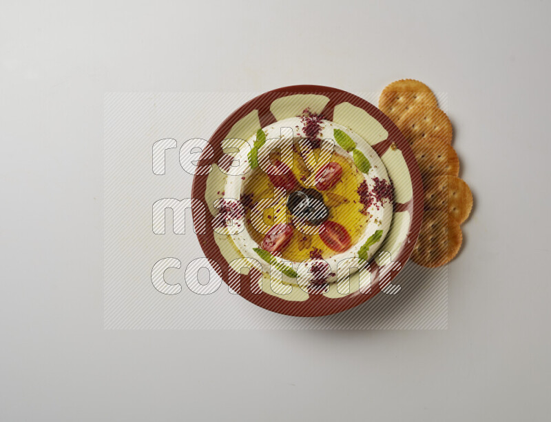 Lebnah garnished with Cherry tomato, mint & sumak  in a traditional plate on a white background