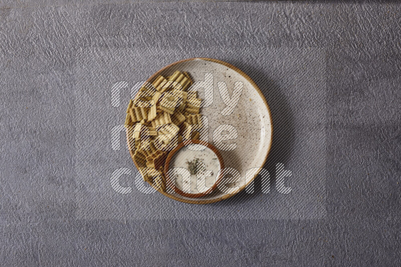 Assorted snacks in pottery bowls on grey background