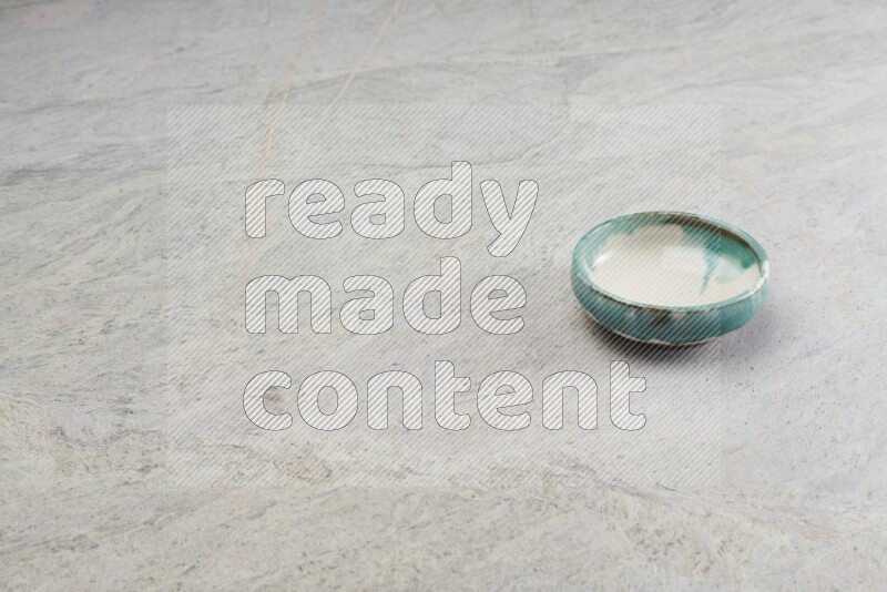 A multicolored pottery bowl on grey marble background