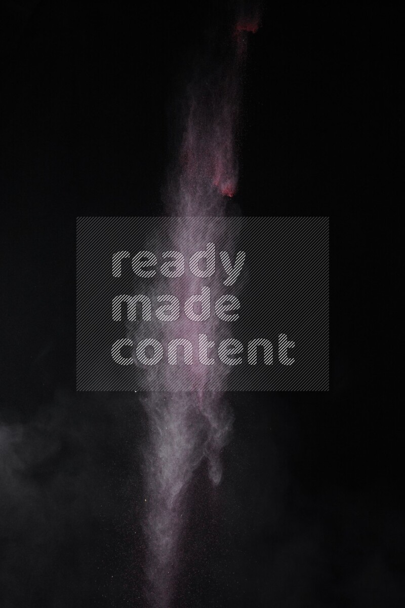 A side view of red powder explosion on black background