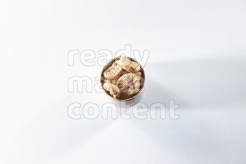 A beige ceramic bowl full of dried figs on a white background in different angles