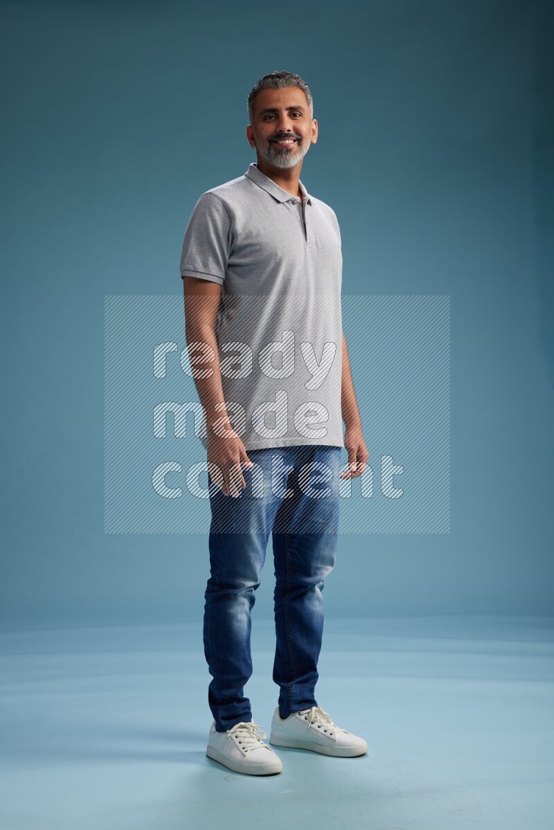 Man Standing Interacting with the camera on blue background